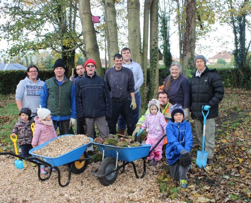 A group volunteers stand in the Centenary Garden at Boultham Park.